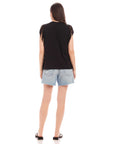 Woman wearing black Nora Fringe Tee with short sleeve fringes and light denim shorts, back view