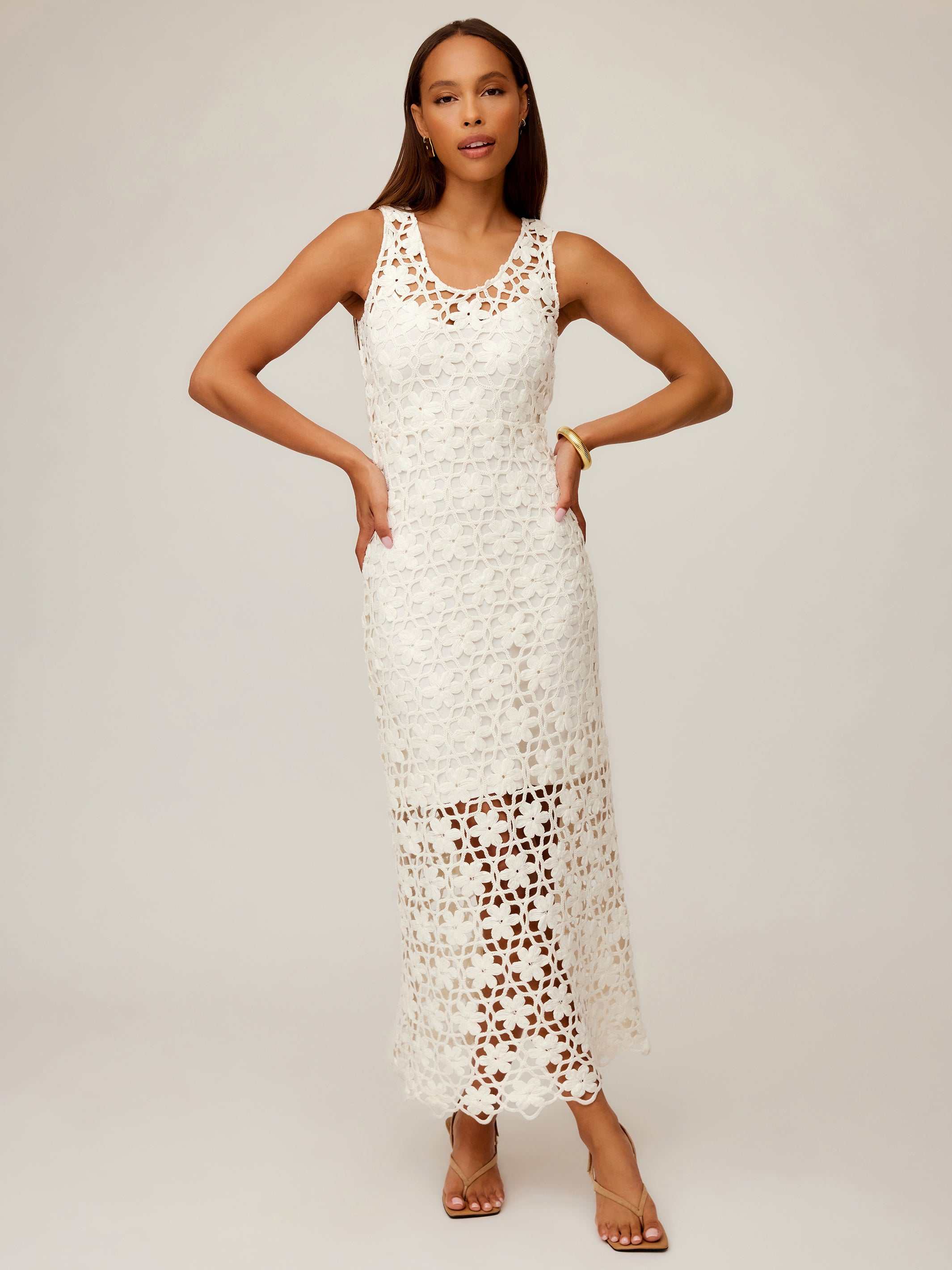 Woman wearing white sleeveless Kelsie Crochet Dress with floral pattern and scoop neckline