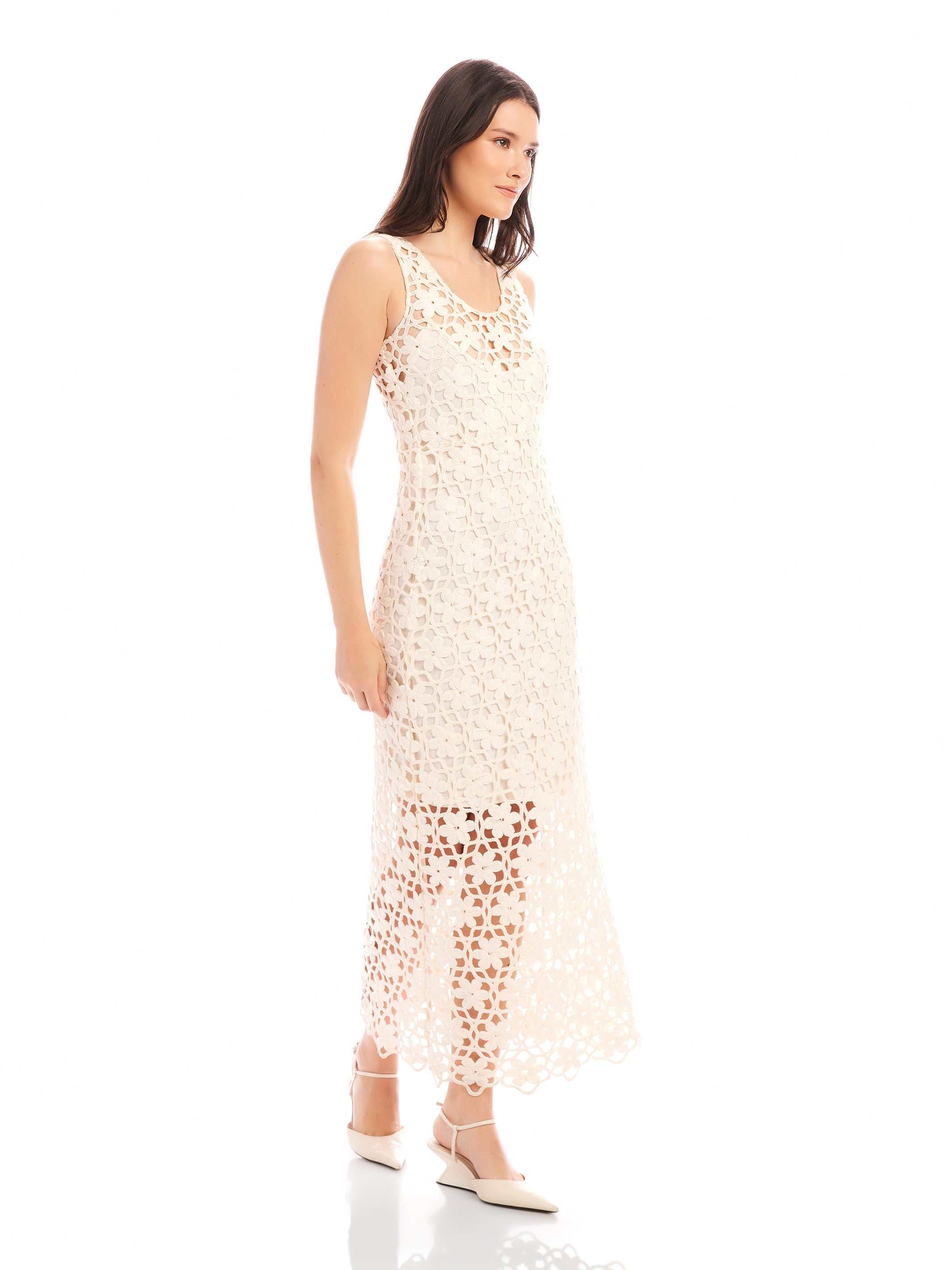 Model wearing a sleeveless Kelsie Crochet Dress with floral design and scoop neckline in white with detachable slip and side zipper closure.