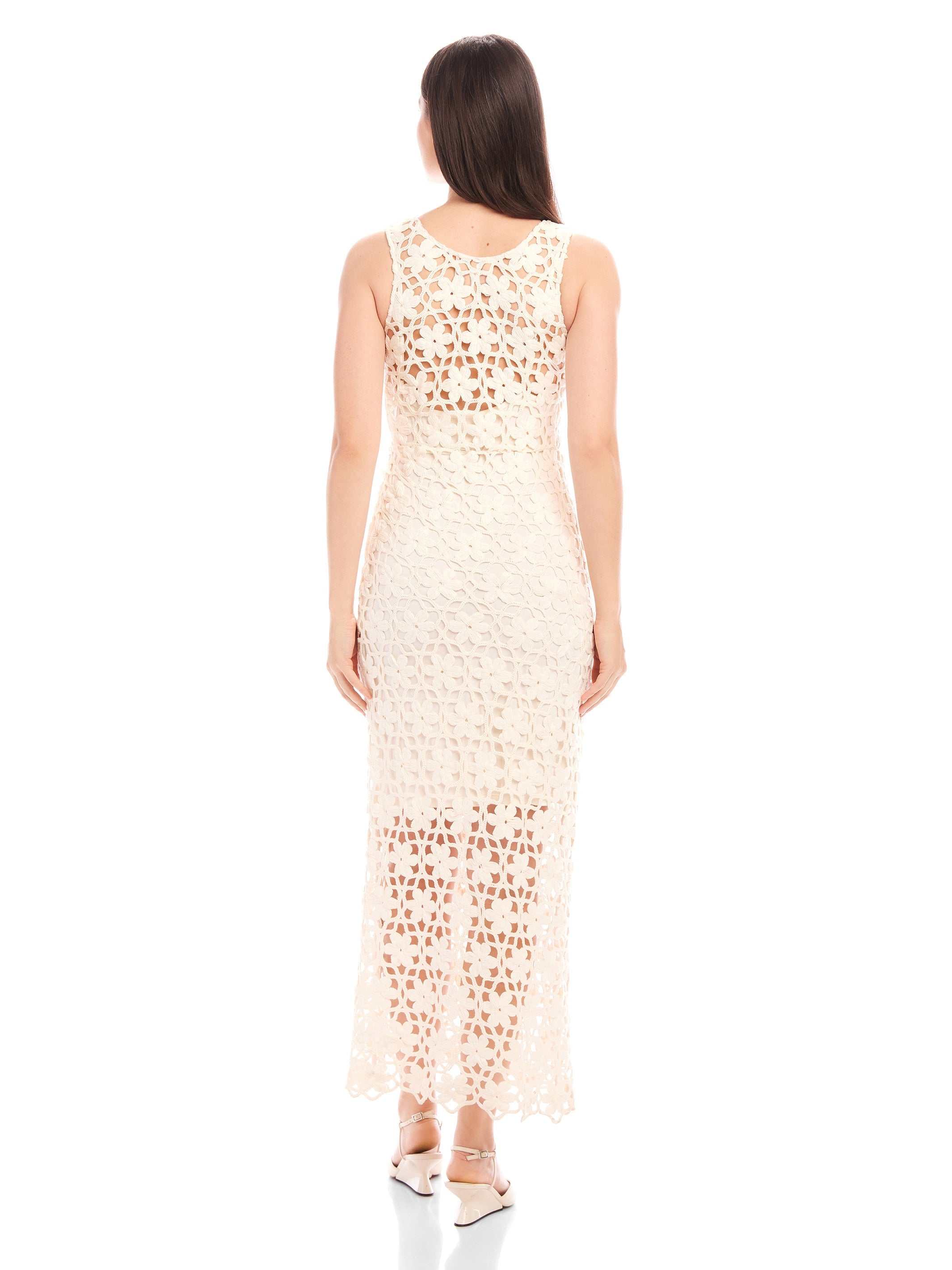 Back view of a woman wearing a sleeveless Kelsie Crochet Dress with floral design and detachable slip, featuring a scoop neckline and side zipper closure.