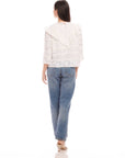 Woman wearing Flora Eyelet Lace Top with floral eyelet design and ruffle trim, paired with blue jeans, shown from back.