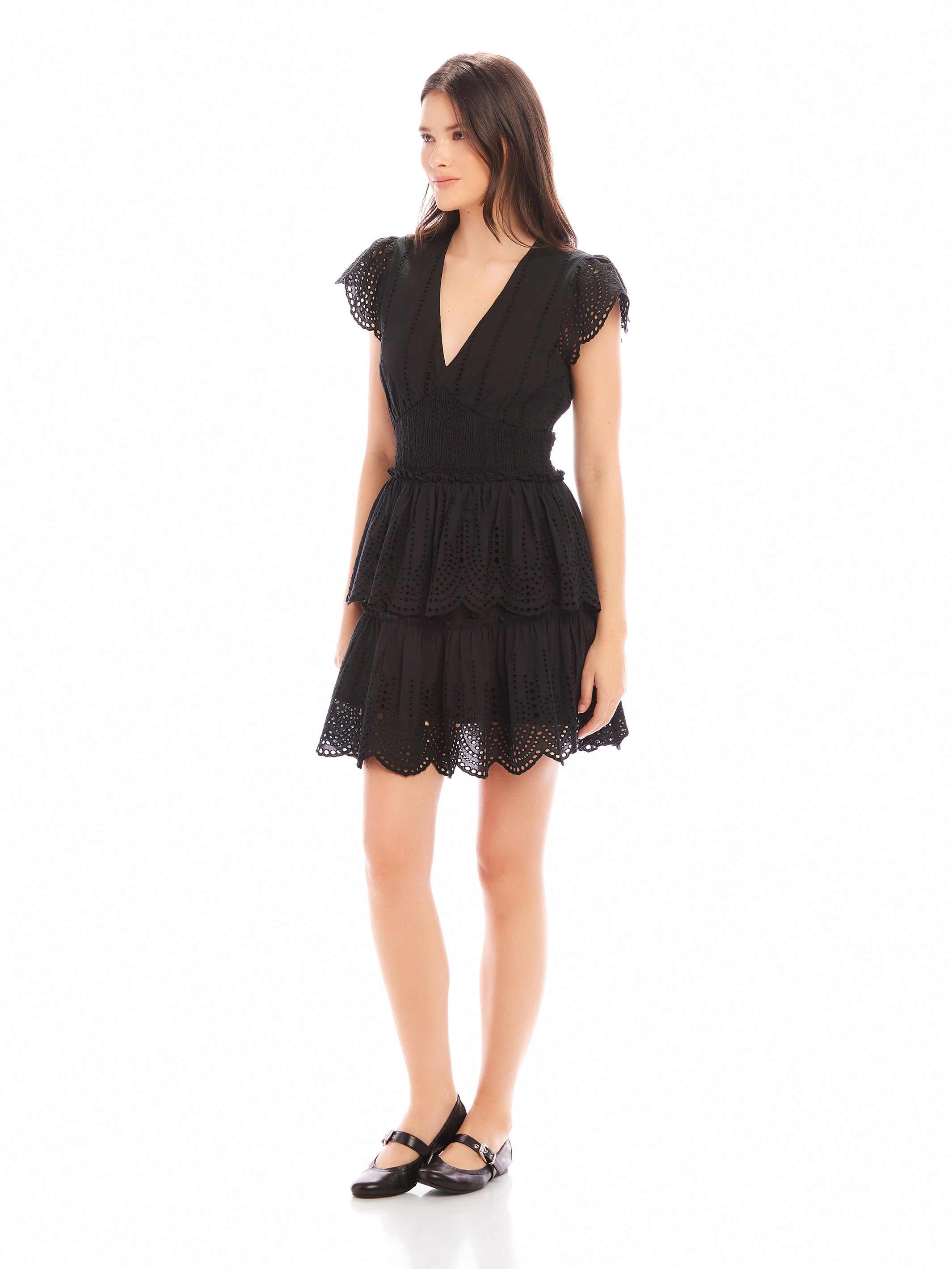 Woman wearing black Isla Embroidered Tiered Dress with fitted waist and cap sleeves