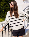 woman wearing white Luca Crewneck Sweater with black stripes and black shorts outdoors