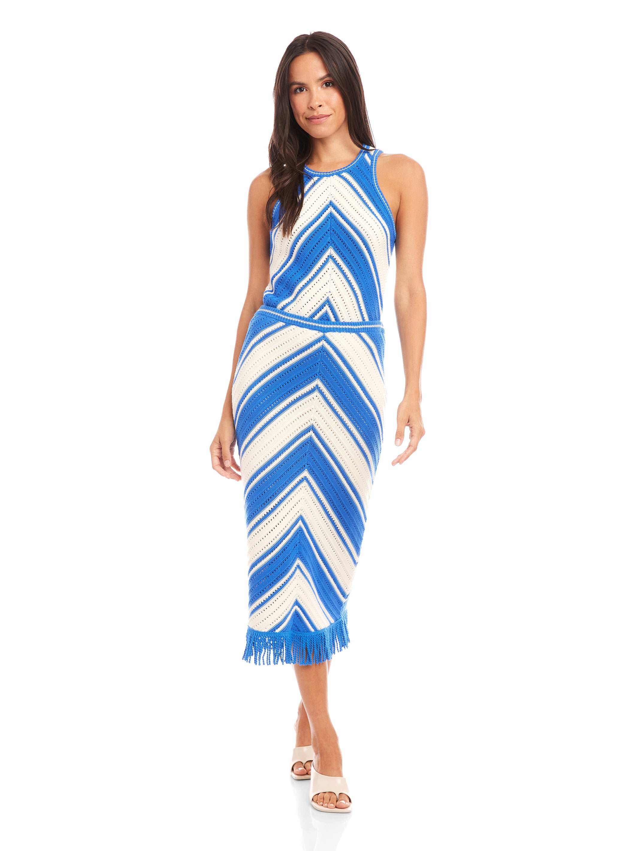 Woman wearing a blue and white amber crochet skirt with chevron pattern and fringe hem paired with matching sleeveless top