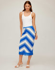 Woman wearing a fitted blue and white chevron pattern Amber Crochet Skirt with fringe hem and white tank top