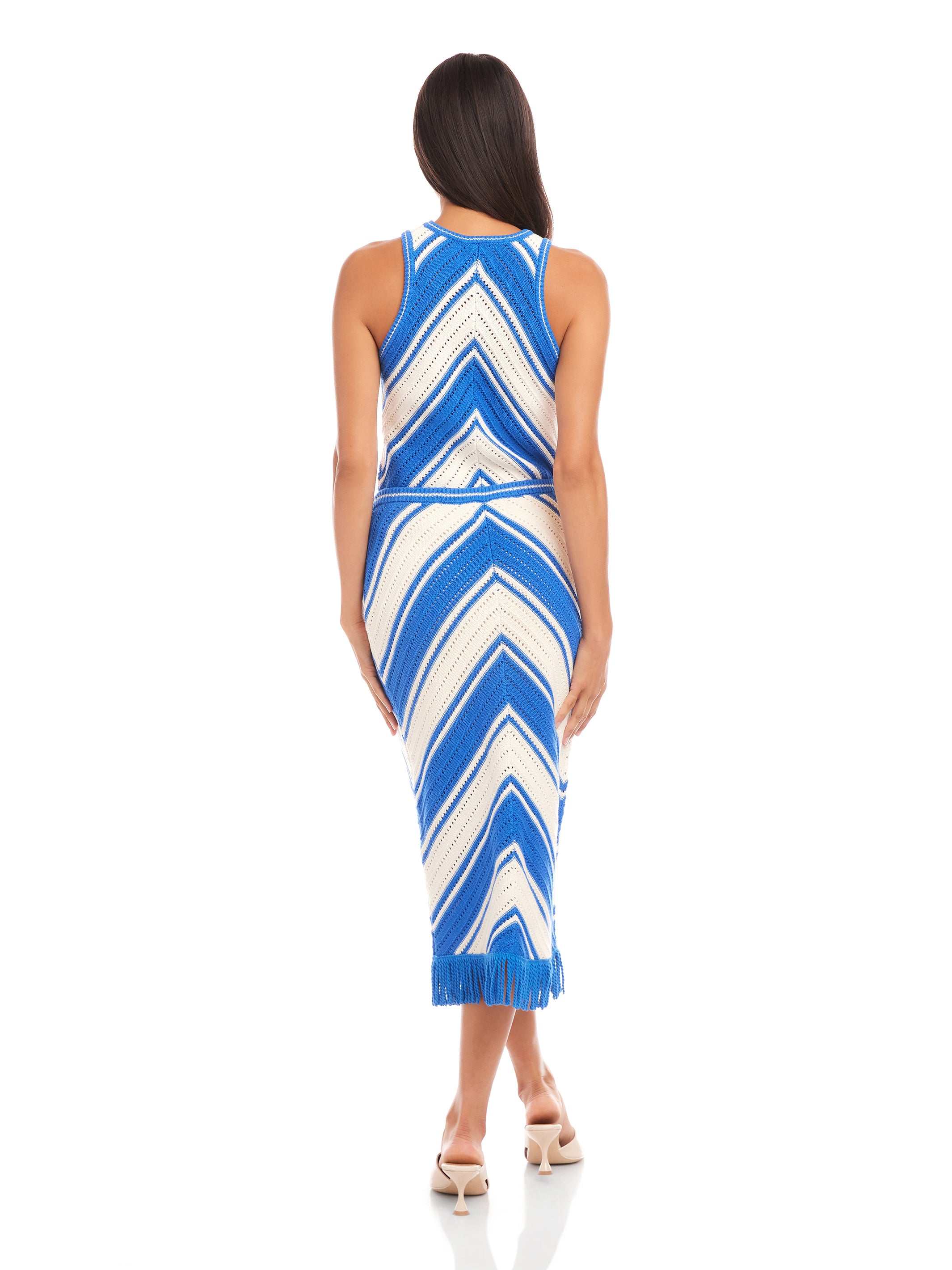 Back view of a woman wearing a blue and white chevron patterned Amber Crochet Skirt with fringe hem and matching tank top