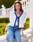 Woman wearing Betsy Crochet Top with white crochet eyelet and blue scalloped edges styled with jeans outdoors