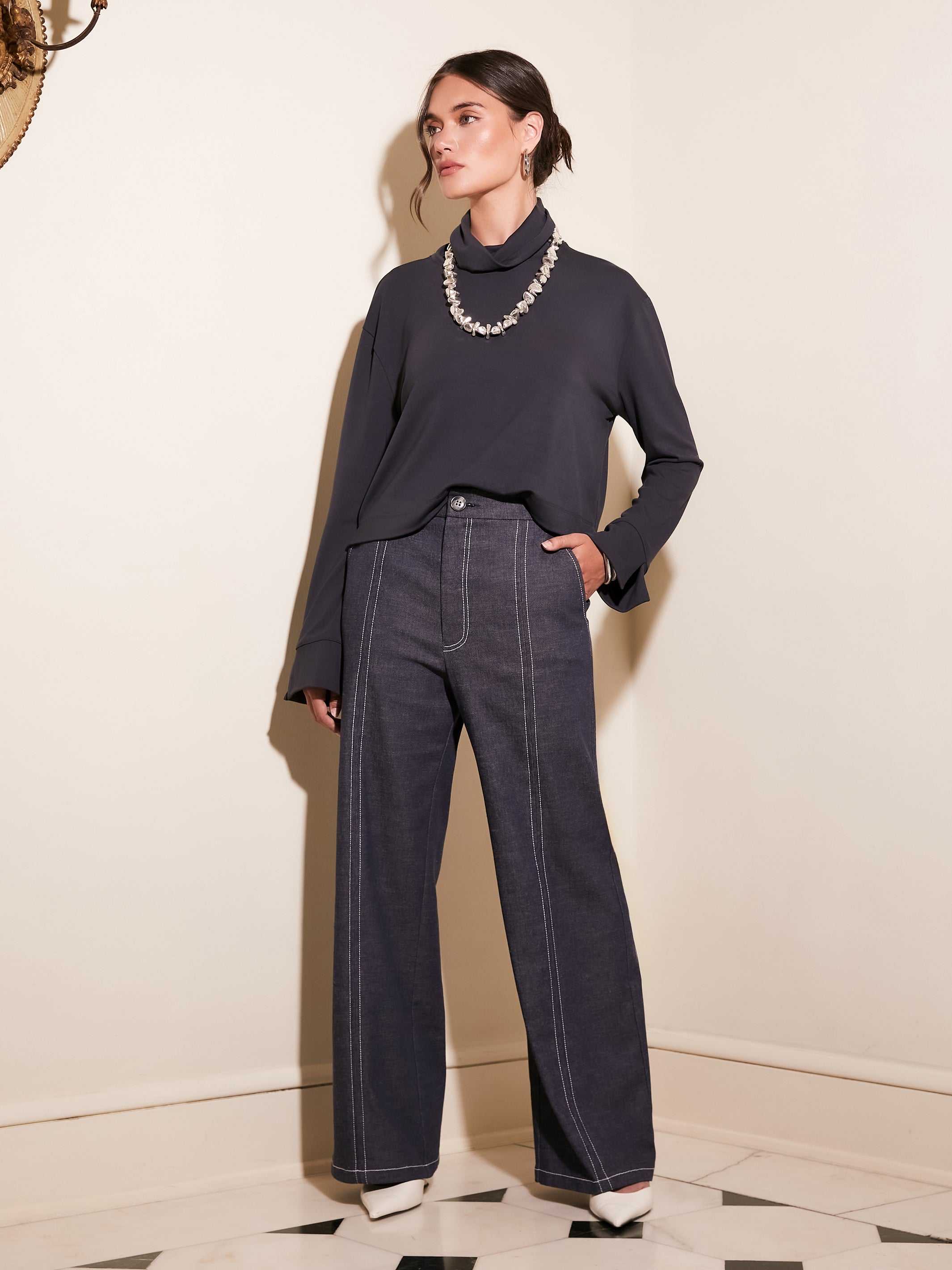 Woman wearing Miles wide-leg trouser in indigo twill with contrast stitching and a black long-sleeve top.