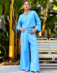 Junie Flared Long Sleeve Top in blue with flare sleeves and boat neck worn by model outdoors