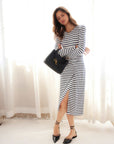 Woman wearing Sadie Side-Drape Midi Dress in heather gray with navy stripes, featuring long sleeves and a front side slit.