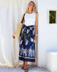Sleeveless Seline Contrast Midi Dress with rib knit bodice, tie waist, and floral printed woven skirt in taupe, green, and off white on blue background