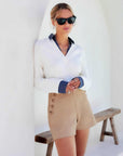 Tailored high-rise button pocket shorts in stretch cotton twill with tortoise button details and side zipper closure