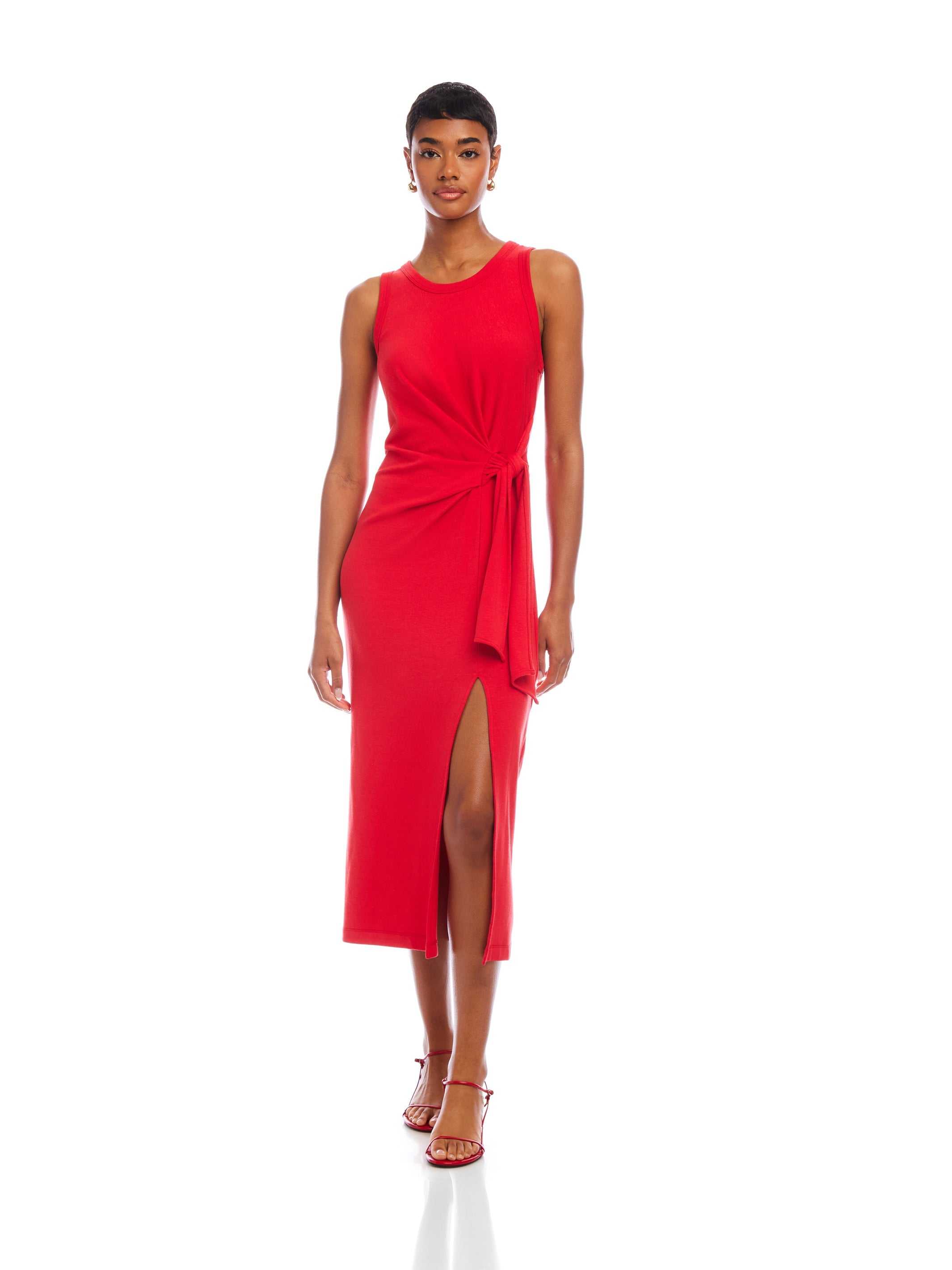 Woman wearing red Maddie Side-Knot Midi Dress with sleeveless design, crew neck, side knot detail, and front slit.