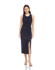 Woman wearing a sleeveless navy Maddie Side-Knot Midi Dress with a side knot detail and slit.