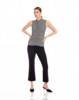 woman wearing black high-rise wide leg Sigourney Pintuck Pants with elastic waist and cropped length, paired with sleeveless striped top and black heels on white background