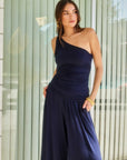 Woman wearing navy Harper One-Shoulder Tie-Top with asymmetrical silhouette and tie detail on shoulder, paired with matching pants