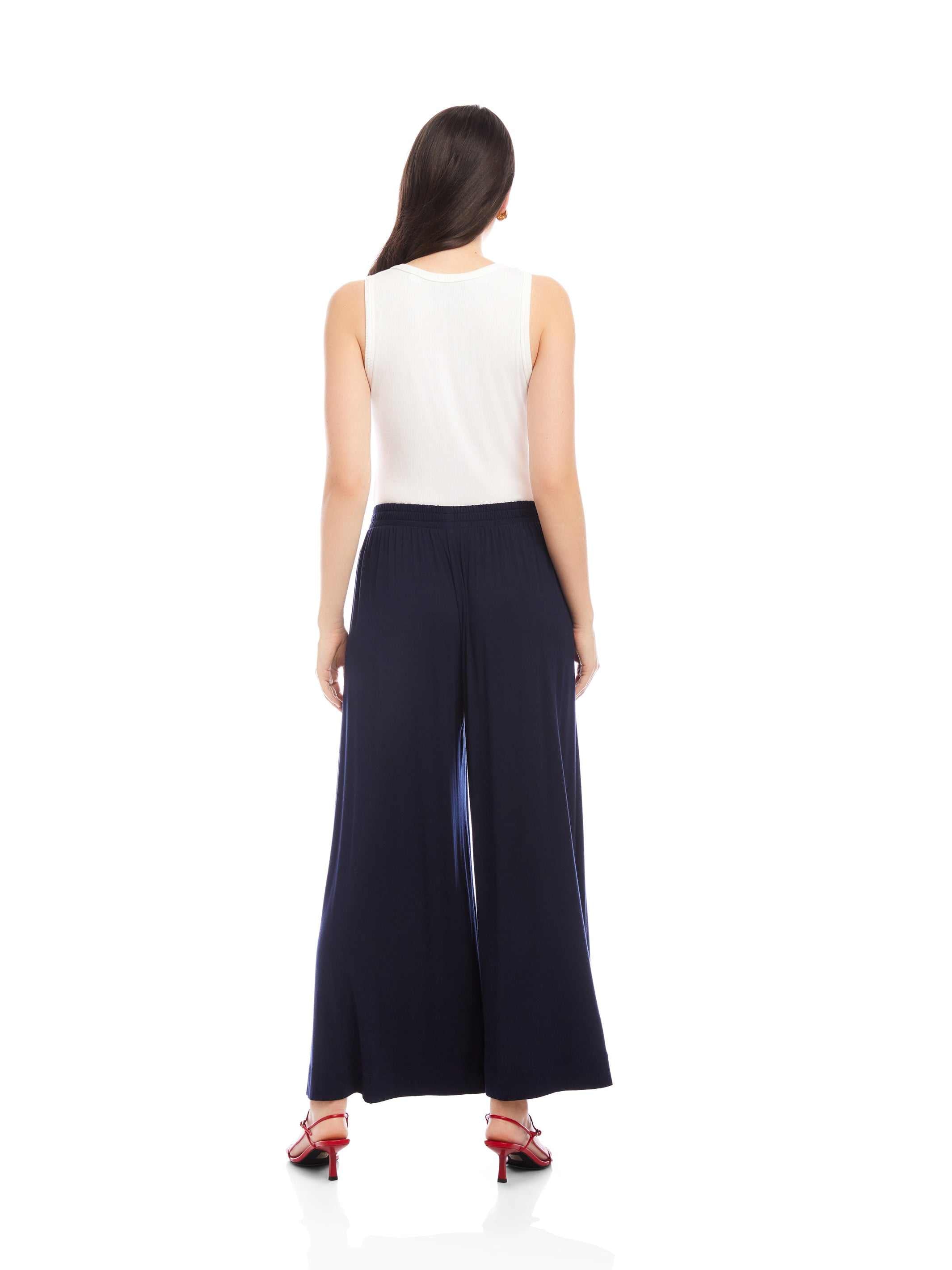 Woman wearing navy Shilo Wide-Leg Ankle Pants with white sleeveless top and red heels, back view