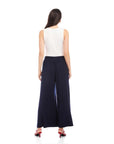 Woman wearing navy Shilo Wide-Leg Ankle Pants with white sleeveless top and red heels, back view