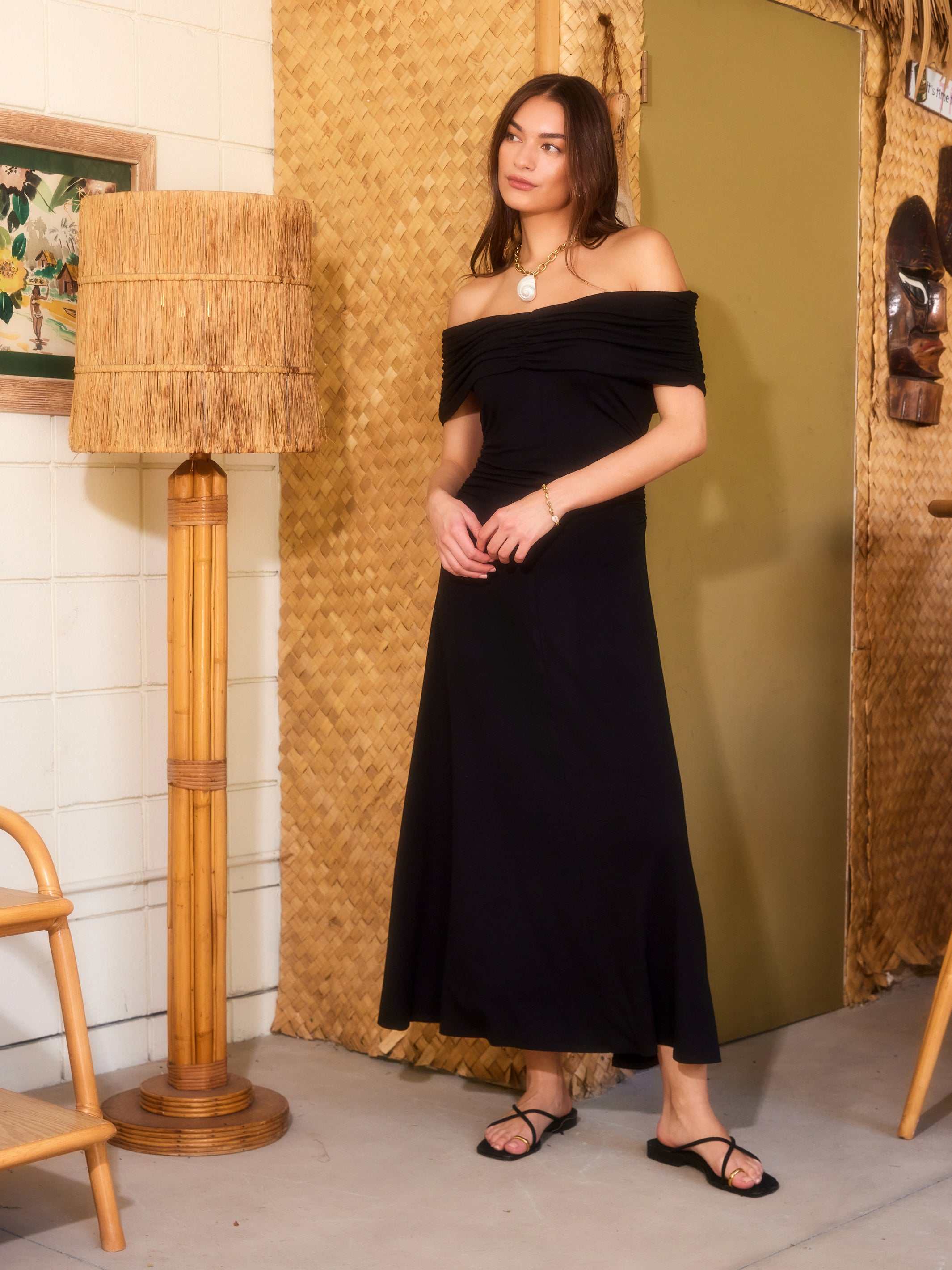 woman wearing black Ella Off-The-Shoulder midi dress with ruched sleeves and A-line silhouette standing indoors