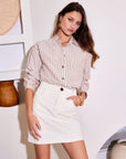 Brynne Skirt in solid ivory twill, with a short A-line silhouette, button-front detail, and side pockets.