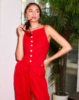 Woman wearing red Elis sleeveless button-up top with white buttons and matching red pants.