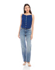 Woman wearing a navy Elis sleeveless button-up top with functional buttons and boat neck paired with light blue jeans and white sandals