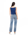Woman wearing a navy Elis sleeveless button-up top with a boxy fit and light blue jeans, shown from the back