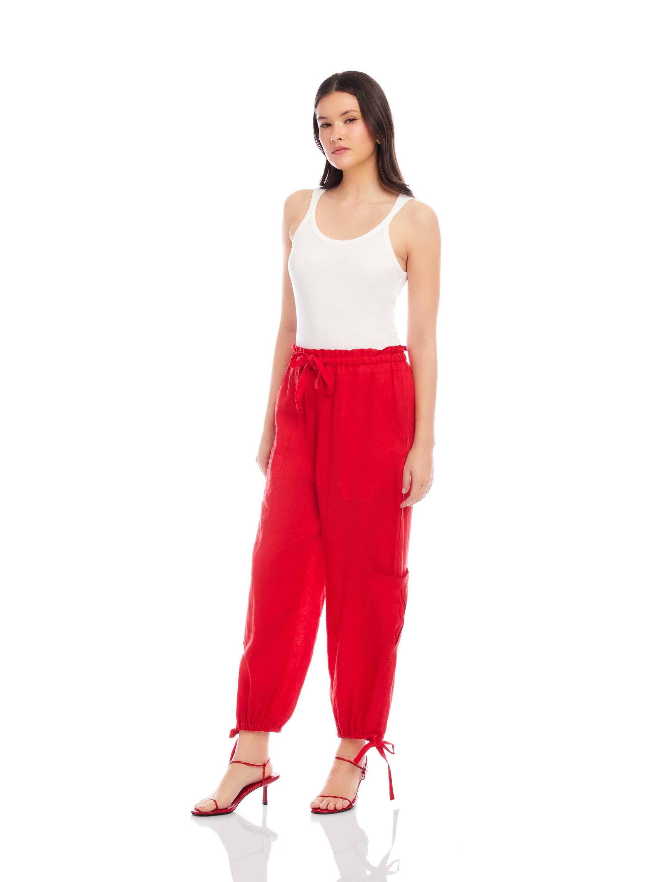 Woman wearing red ankle-length Charo Cargo Pants with drawstring hems and front pockets