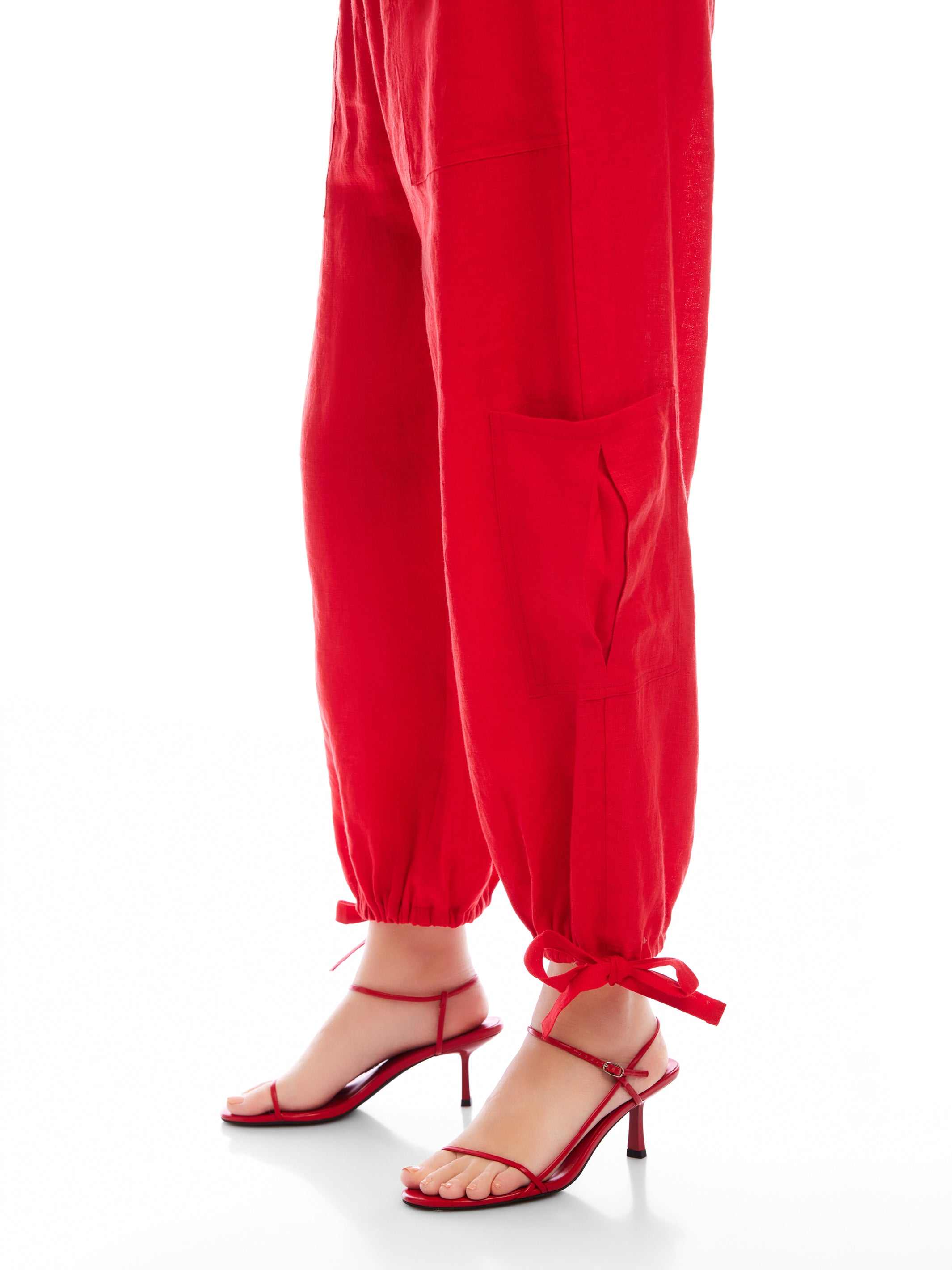 Red Charo Cargo Pants with ankle-length fit, front and side pockets, and adjustable drawstring hems.