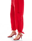 Red Charo Cargo Pants with ankle-length fit, front and side pockets, and adjustable drawstring hems.