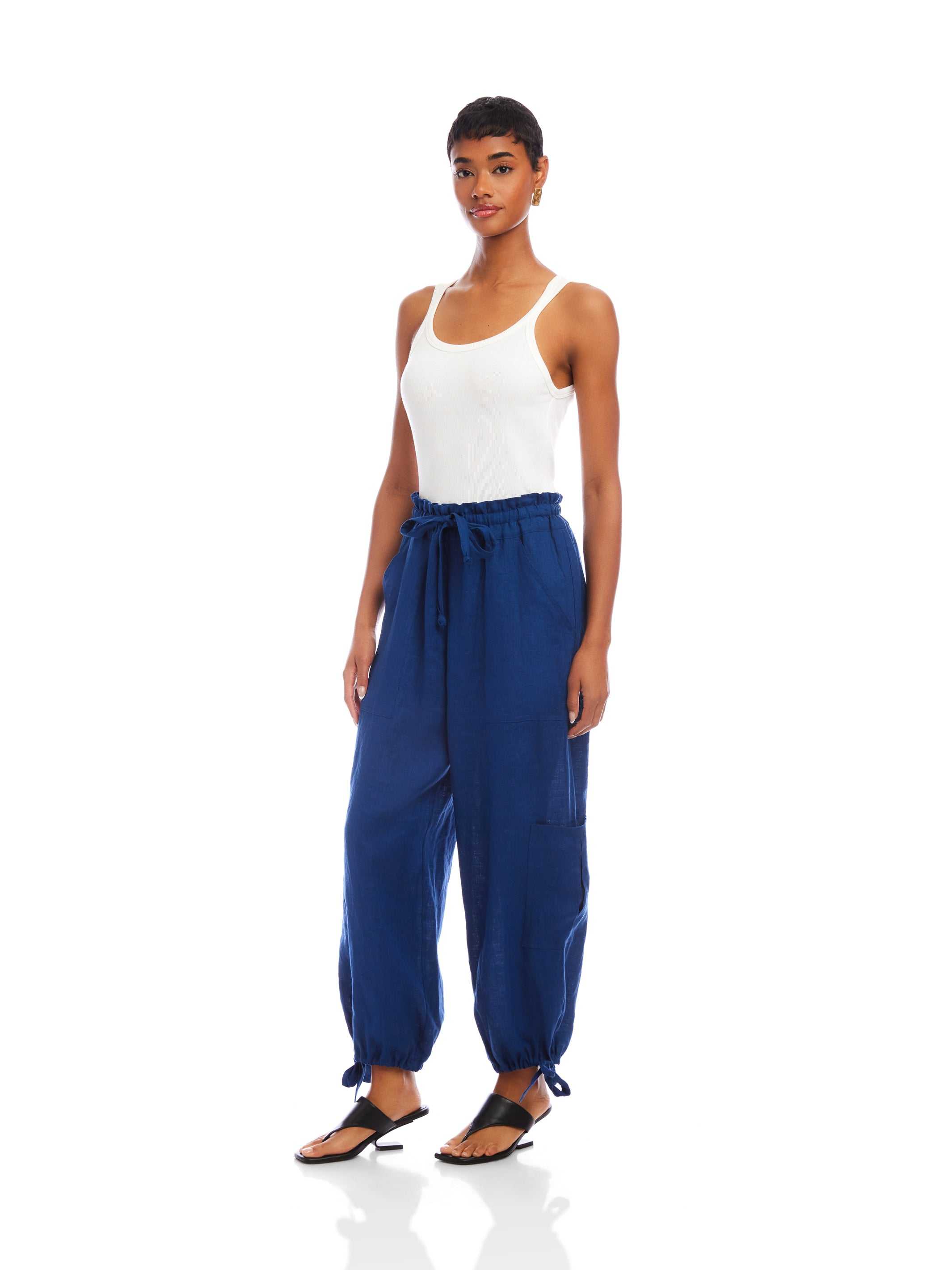 Woman wearing blue ankle-length Charo Cargo Pants with adjustable drawstrings and front and side-leg cargo pockets