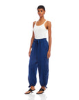 Woman wearing blue ankle-length Charo Cargo Pants with adjustable drawstrings and front and side-leg cargo pockets