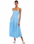 Woman wearing light blue Jessa Midi Dress with adjustable straps and side pockets, sleeveless with scoop neck design.