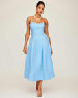 Woman wearing light blue sleeveless Jessa Midi Dress with adjustable straps and side pockets.