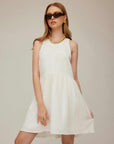Woman wearing sleeveless white Cianni Tie-Neck Dress with scoop neck and relaxed fit