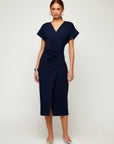 Woman wearing navy blue Luna Midi Dress with cap sleeves and crossover V-neckline