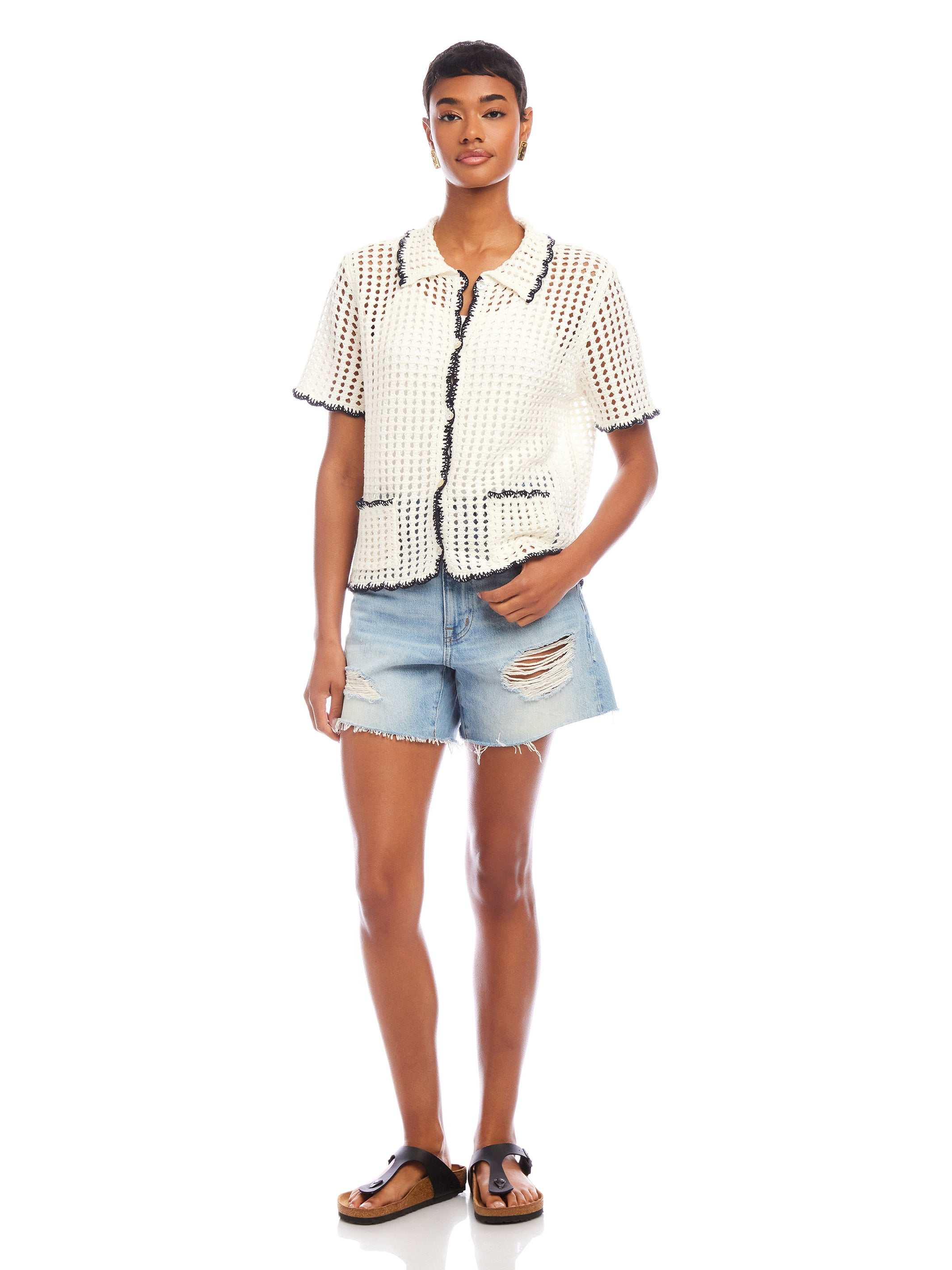 Woman wearing Gemma Crochet Shirt with contrast stitch crochet collar and pockets paired with distressed denim shorts and sandals