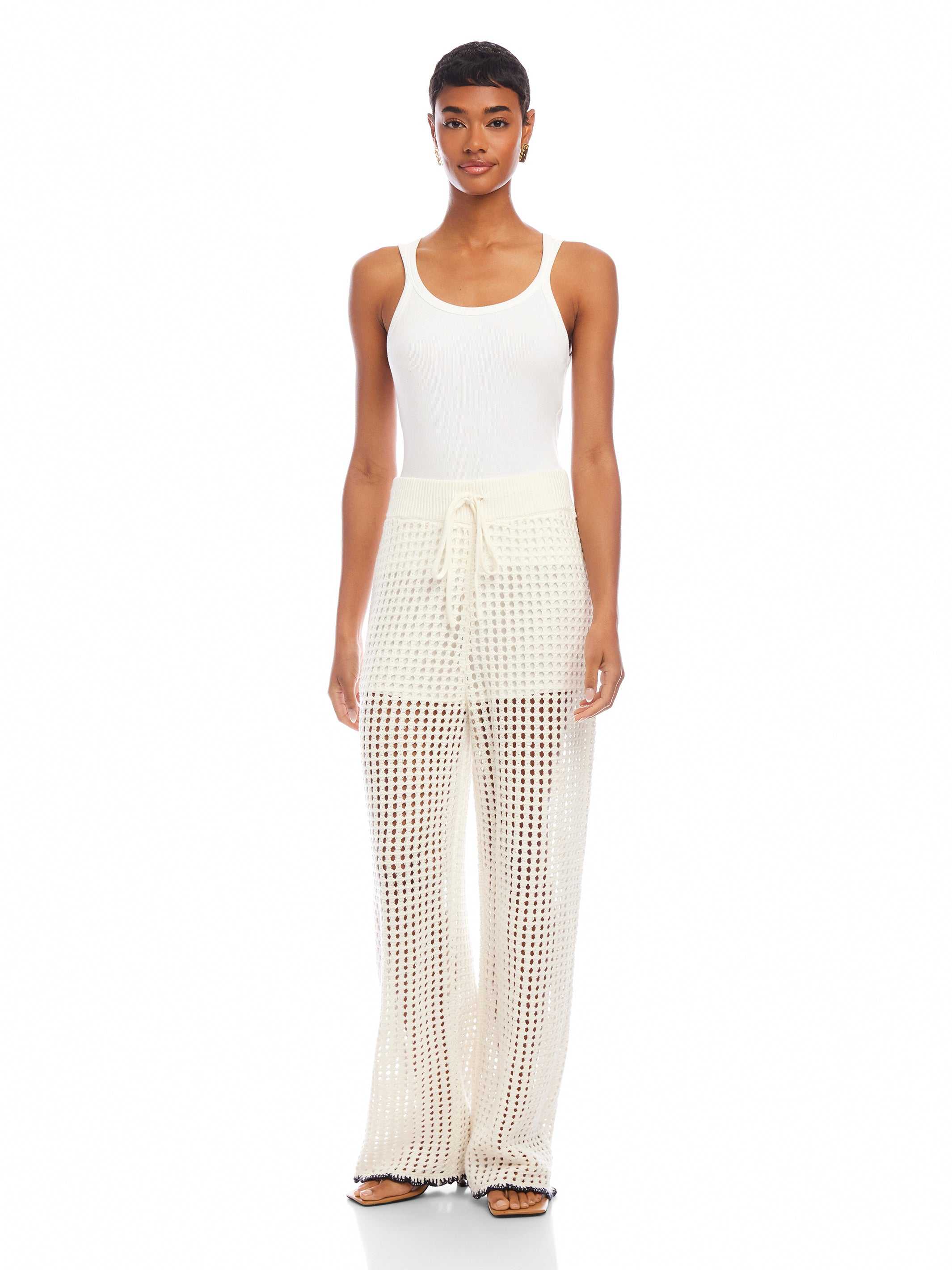 Woman wearing white Gianna crochet pants with drawstring waist and wide leg design