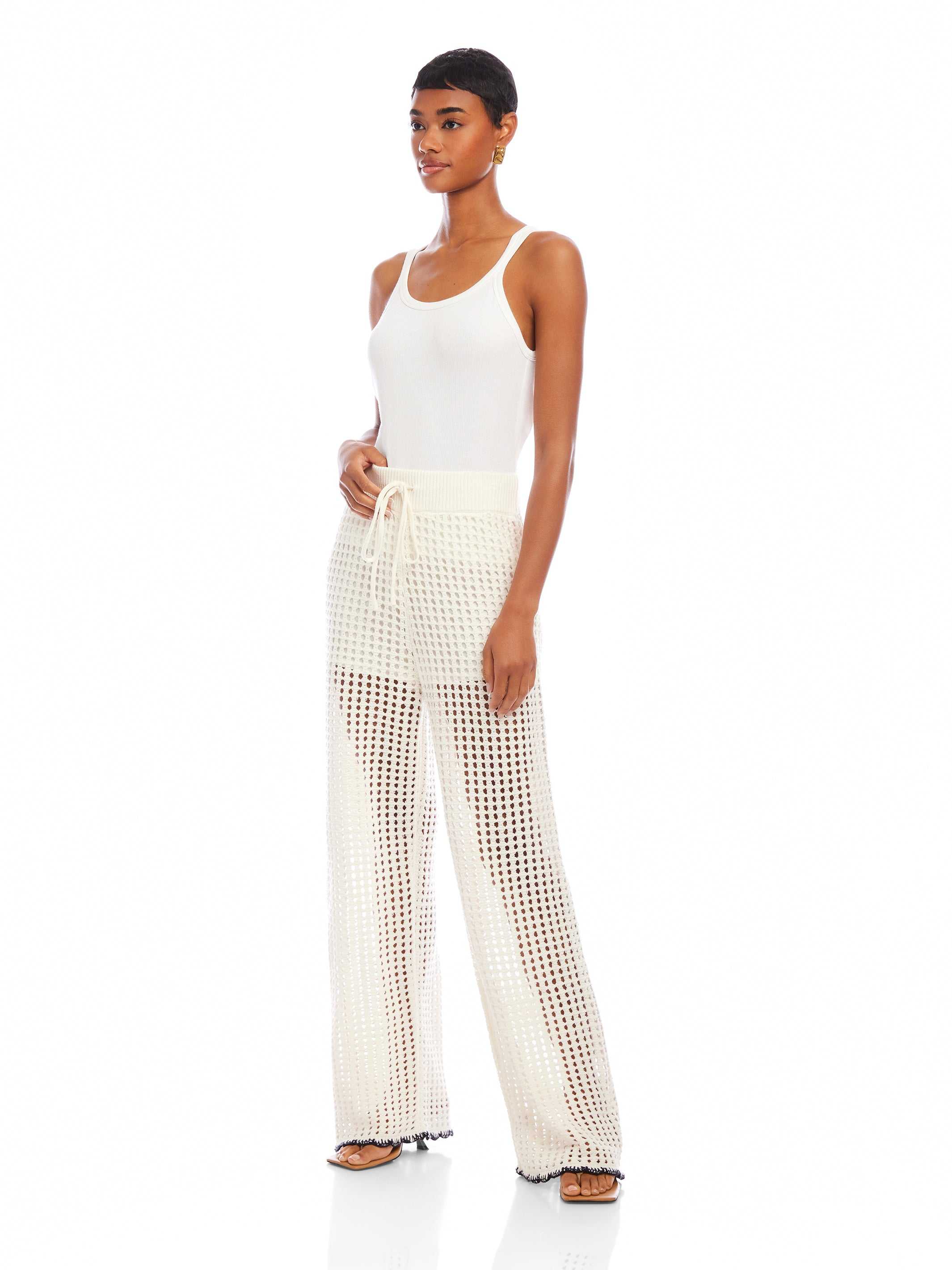 Woman wearing white Gianna crochet pants with drawstring waist and wide leg design
