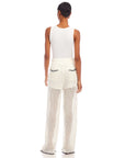 Woman wearing white Gianna crochet pants with contrast stitch, wide leg, scalloped edges, and back pockets, paired with a white sleeveless top, view from the back.
