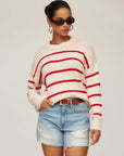 Woman wearing oversized Luca Crewneck Sweater with red stripes and drop shoulder sleeves paired with denim shorts