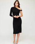 Model wearing black Nadia Dress with asymmetric neck and one long sleeve, fitted silhouette, and midi length.