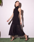 Woman wearing sleeveless black Liana Contrast Lace Dress with fitted ribbed knit top and lace bottom walking in strappy heels