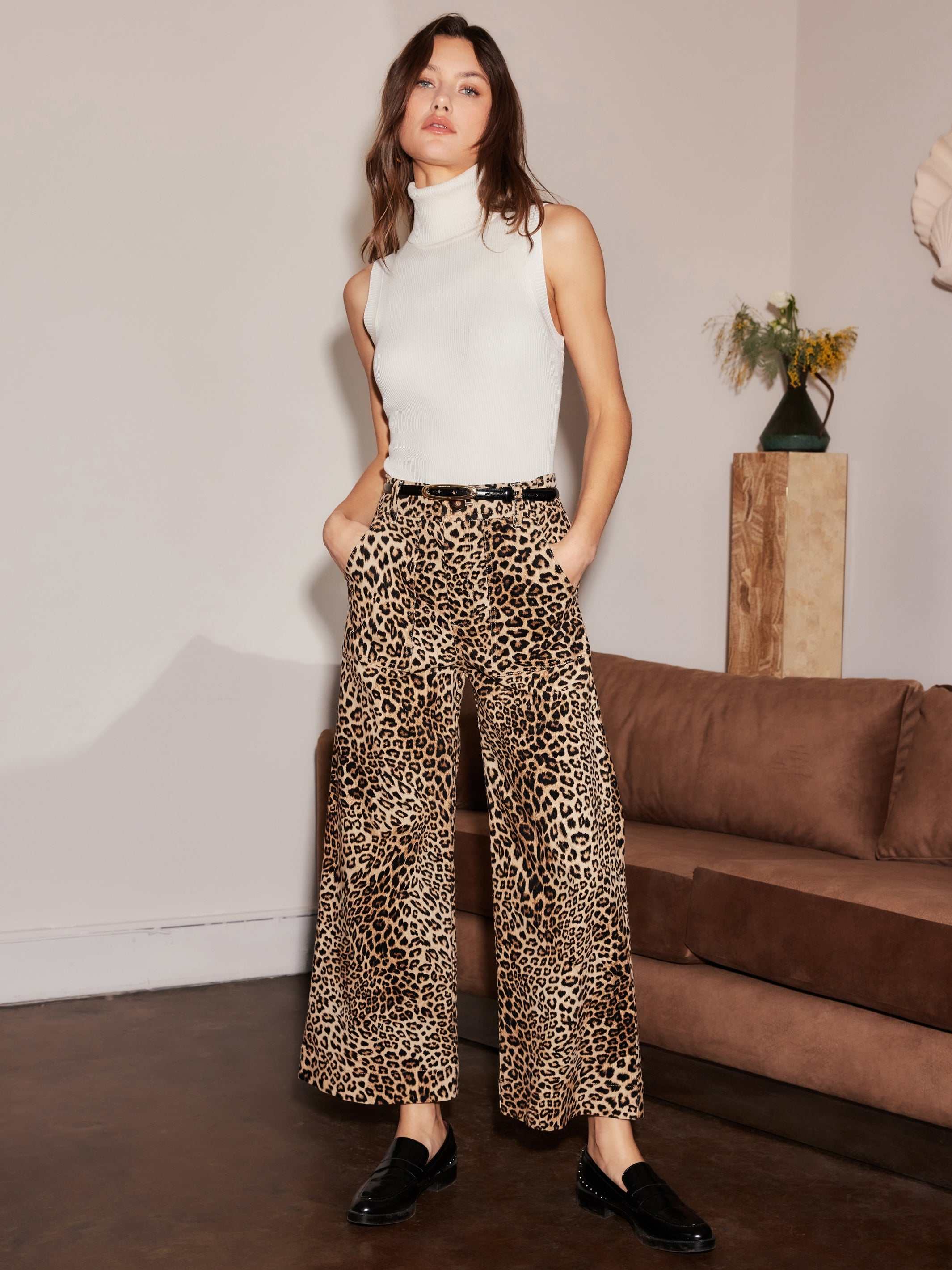 Woman wearing leopard print wide-leg cropped Rylee Cropped Pants with sleeveless white turtleneck and black shoes indoors
