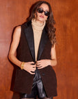 Woman wearing Brooklyn Blazer Vest with faux leather collar and oversized fit over beige turtleneck sweater