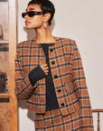 woman wearing brown brushed plaid Jackie Micro Jacket with faux leather buttons and matching skirt indoors