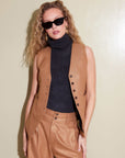 Woman wearing Sutton Vest sleeveless button-down vest styled with black turtleneck and matching pants