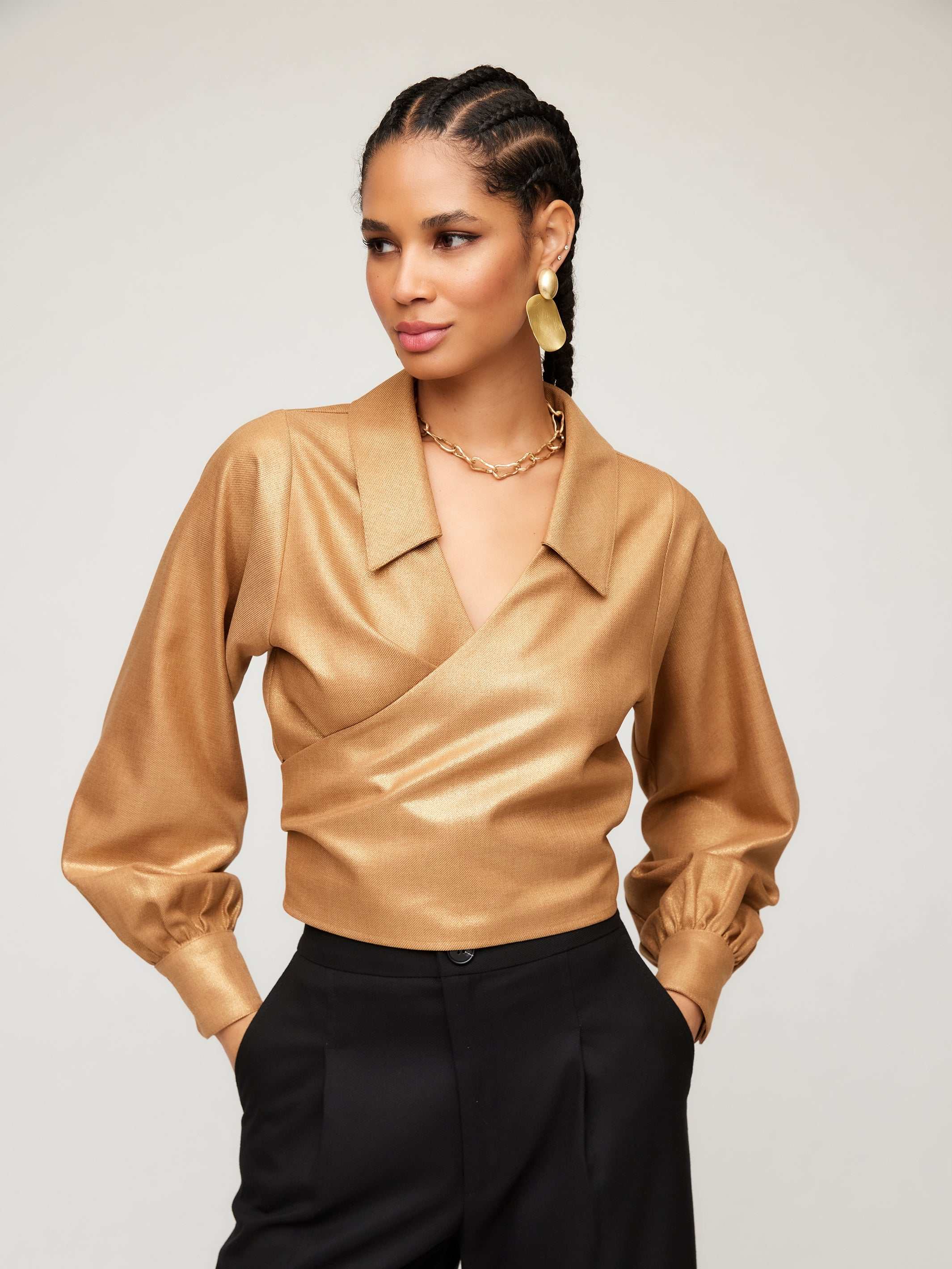 Gold foil print Sloane Wrap Shirt with bishop sleeves and crossover V-neck collar worn with black pants
