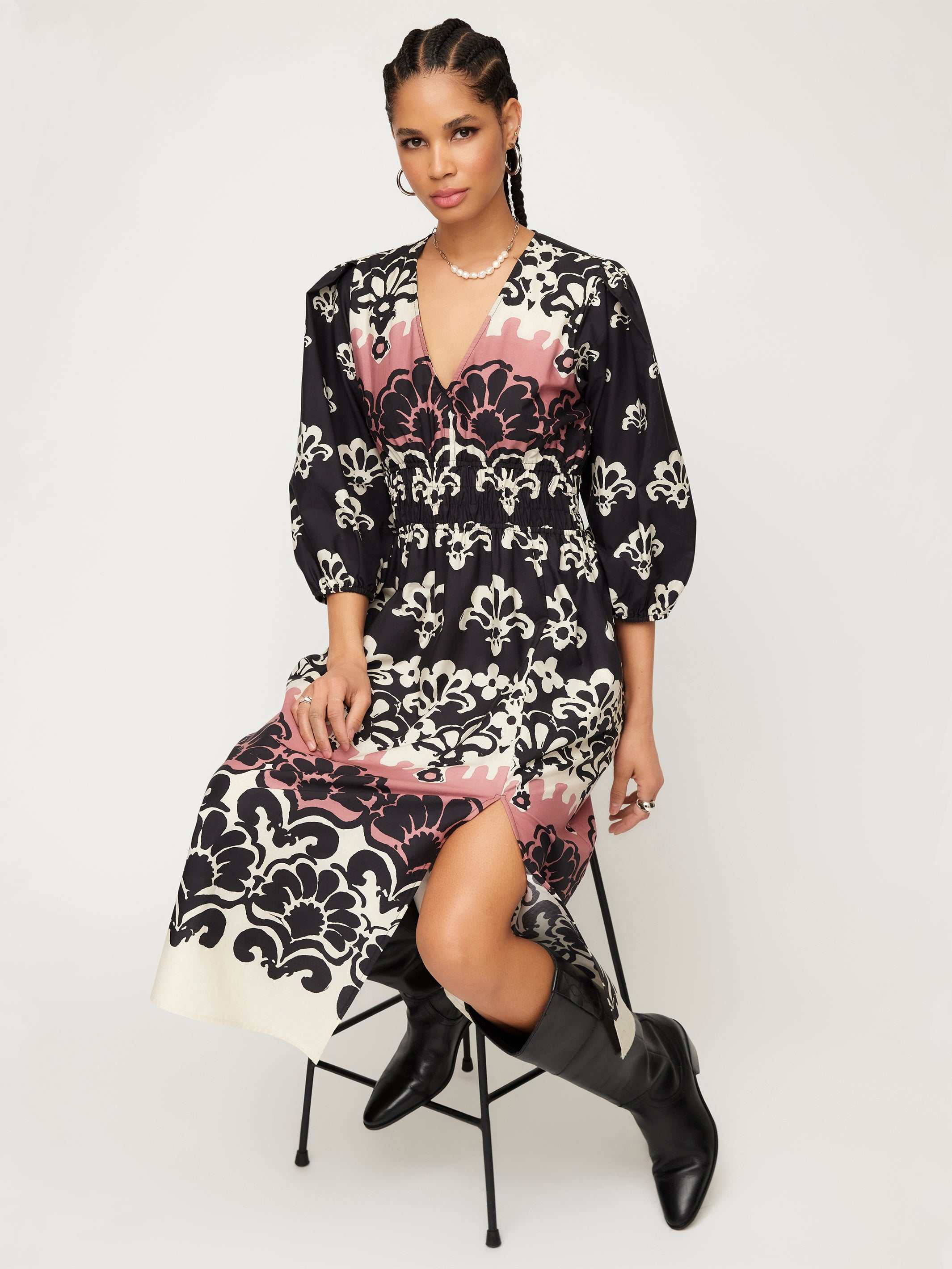 Woman wearing a Lizbeth Shirred Waist Dress with Italian damask block print, V-neck, 3/4 bishop sleeves, side slit, and pockets.