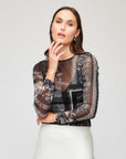 Woman wearing Alina Side-Shirred Top with bandana mesh print and sheer long sleeves.